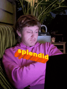 a man wearing a pink sweatshirt with the word splendid written on it