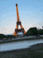 the eiffel tower is lit up at night and surrounded by people