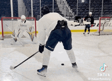 a hockey player wearing bauer shorts is holding a puck