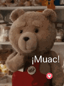 a teddy bear wearing red overalls has a help button on his chest