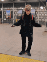 a person standing in front of a wall with a sign that says ' subway ' on it