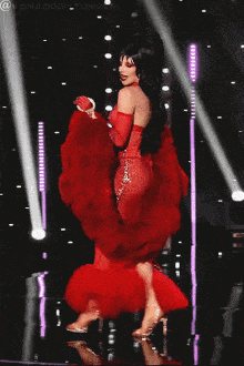 a woman in a red dress is dancing on a stage with the hashtag @vcnxodd