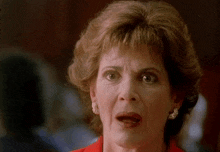 a close up of a woman 's face with a surprised expression on her face .