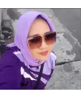 a woman wearing a purple scarf and sunglasses takes a selfie