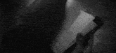 a black and white photo of a person watering a flower .