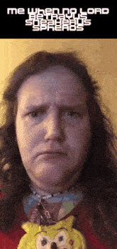 a man with long hair is wearing a spongebob necklace and making a sad face