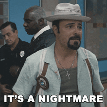 a man in a hat stands in front of two police officers with the caption " it 's a nightmare "