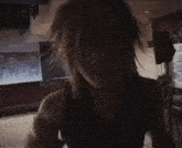 a close up of a woman 's face in a dark room with a microphone .