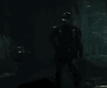 a man wearing a helmet is walking through a dark cave
