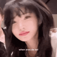 a close up of a girl 's face with the words `` when eres de bel '' written on it .