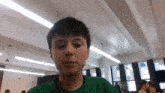 a young boy wearing a green shirt is looking at the camera