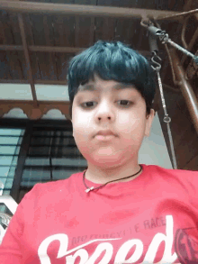 a young boy wearing a red shirt that says good