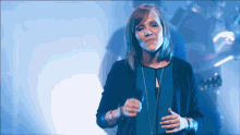 a woman is singing into a microphone on a stage
