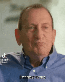 a man in a blue shirt is talking in a foreign language .