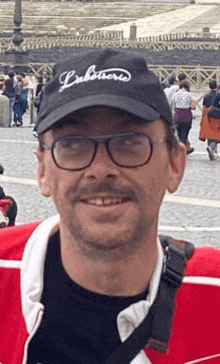 a man wearing glasses and a black hat with the word lobsters on it is smiling