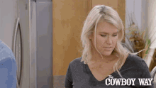 a woman stands in front of a refrigerator with the cowboy way written on it