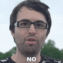 a man wearing glasses and a beard is saying no .