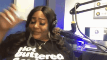 a woman wearing headphones and a shirt that says hot buttered on it