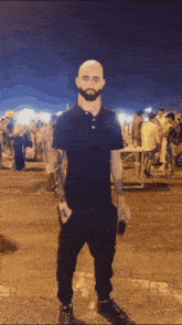 a bald man with a beard is standing in a crowded parking lot
