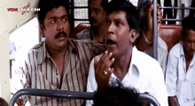 a group of men are sitting on a bus and the website videsaur.com is visible