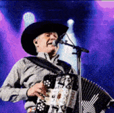 a man singing into a microphone while playing an accordion