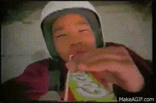 a person is drinking a juice through a straw from a box .