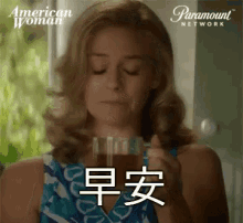 a woman is drinking a cup of coffee with chinese writing on it