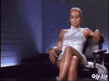 a woman in a white dress is sitting in a chair with her legs crossed ..