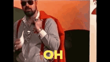 a man with a beard and sunglasses is wearing a red cape and suspenders and a necklace .