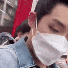 a man wearing a face mask is looking down at something .