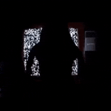 a silhouette of a person standing in front of a door in the dark .