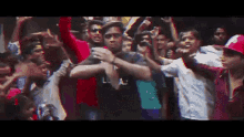 a group of people are dancing in a crowd and one of them is wearing a shirt that says ' la ' on it