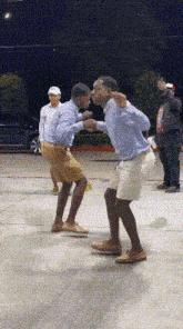 a couple of men are dancing on a concrete surface