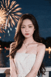a woman stands in front of a fireworks display