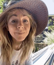 a woman wearing a hat and a t-shirt that says eb