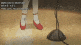 a girl in red shoes is standing in front of a microphone with the words head over head over heels .
