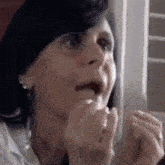 a close up of a woman 's face with her mouth open and a surprised look on her face .
