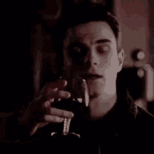 a man is holding a glass of wine in his hand .
