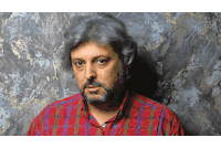 a man with grey hair and a beard wearing a red plaid shirt