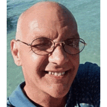 a close up of a man wearing glasses and a blue shirt .