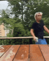 a man in a black shirt is standing on a wooden table