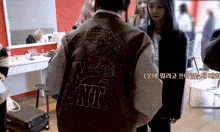 a person wearing a brown jacket with the word unit on the back