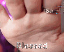 a close up of a person 's hand with the word blessed below it