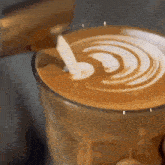 a cup of coffee with a swirl of milk on top