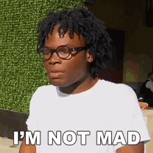 a man wearing glasses and a white t-shirt says i 'm not mad