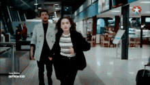 a man and a woman are walking down a hallway with the words sefirin kizi on the bottom right