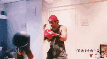a man wearing boxing gloves is standing in a room with the word toree written on the bottom