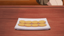a person is reaching for a plate of cookies on a table