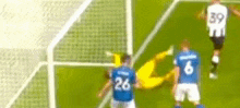 a group of soccer players are playing a game on a field . one of the players has the number 26 on his shirt .