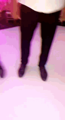 a person 's legs are shown in a blurry photo with purple lights behind them